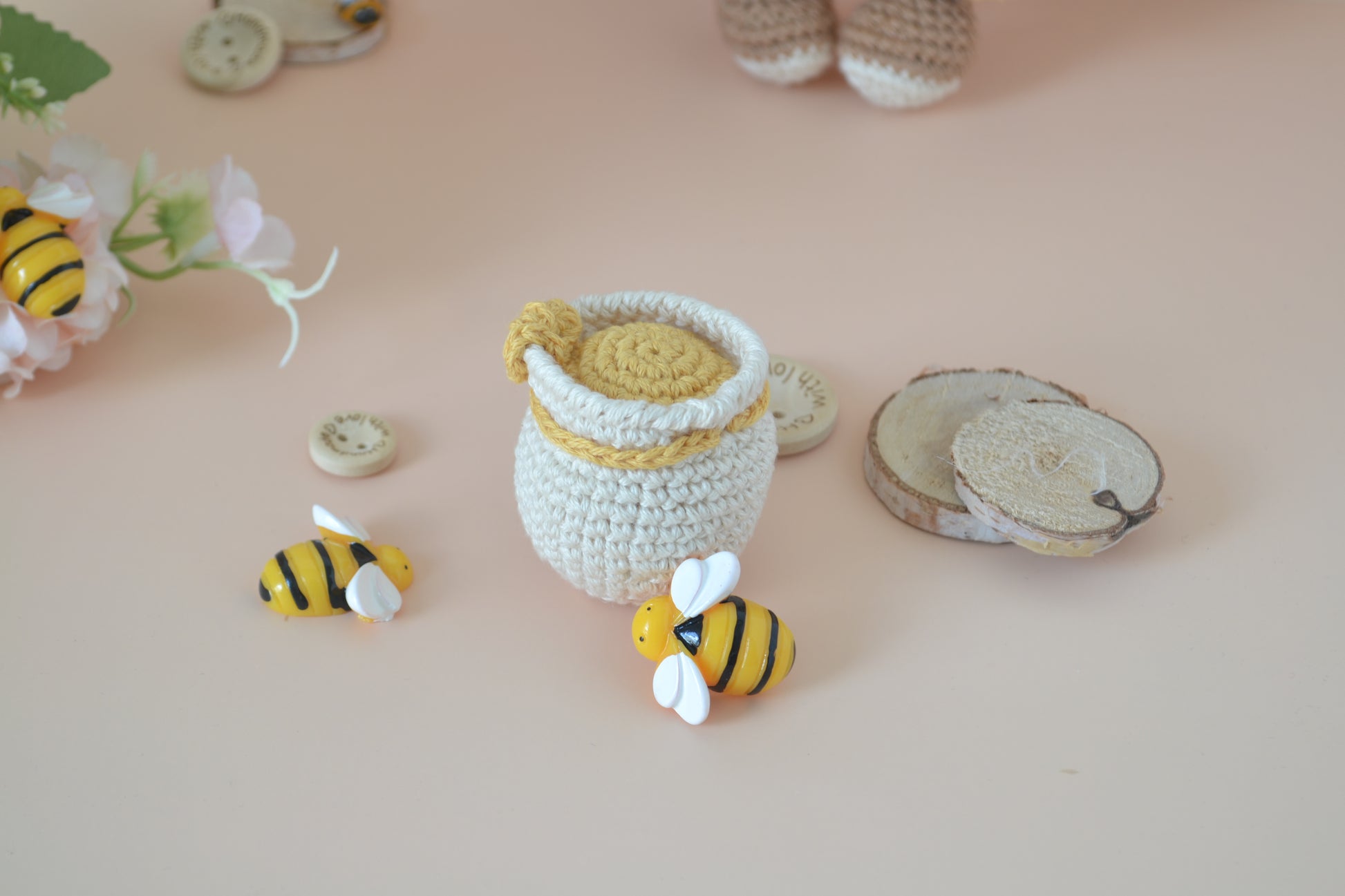 Honigfass mit Bienen und Holzdeko Elemente drum herum.