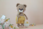 Honilo der Honigbär mit Löffel in der Hand und Honigfass daneben, Blumen, Bienen und Holz