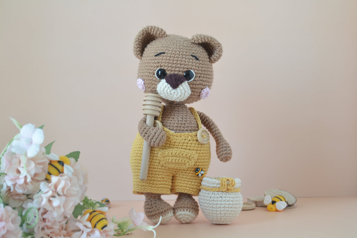 Honilo der Honigbär mit Löffel in der Hand und Honigfass daneben, Blumen, Bienen und Holz