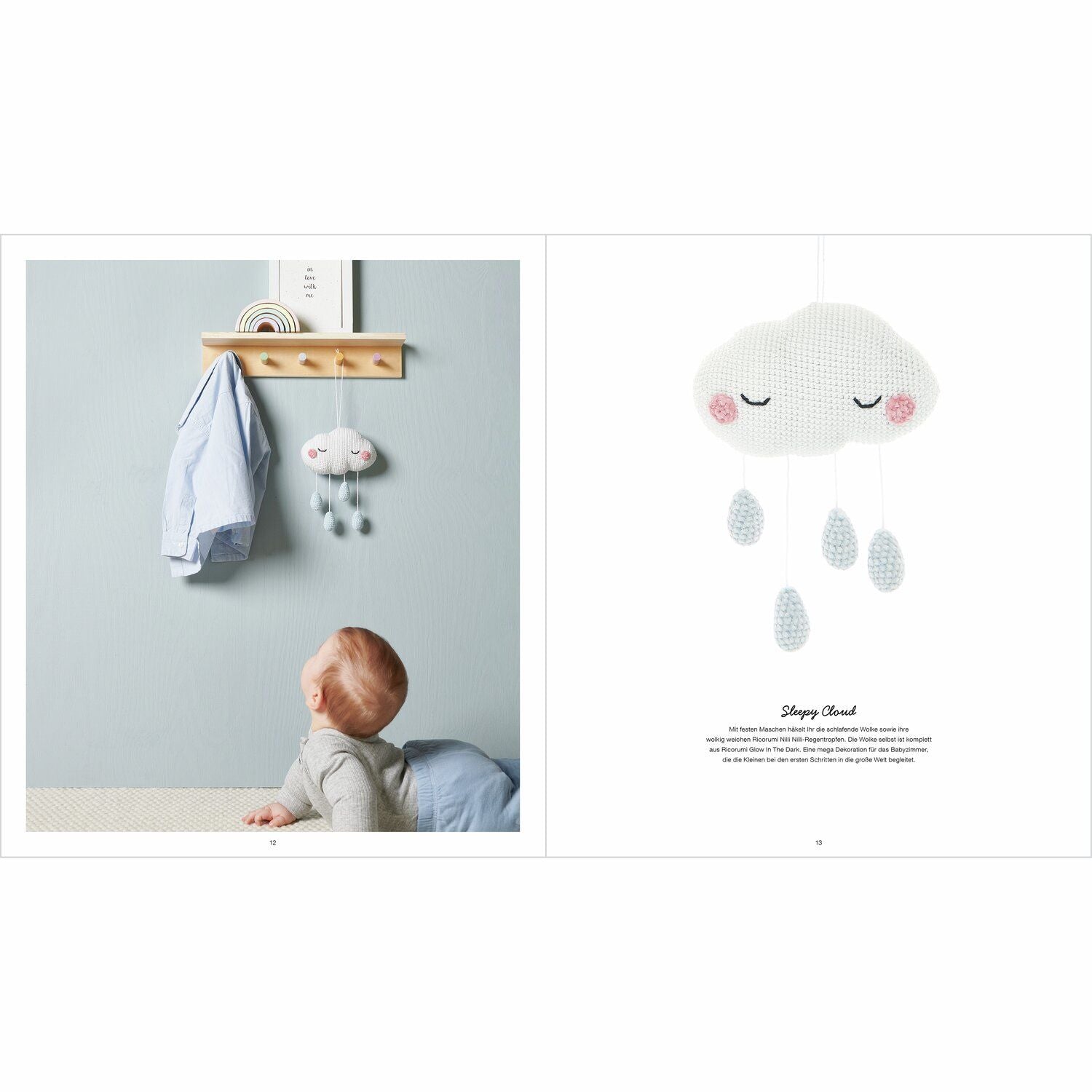Ein Baby schaut sich eine gehäkelte Regenwolke an, die Regenwolke hat schlafende Augen aufgestickt und es hängen 4 Regentropfen in Hellblau herunter. 